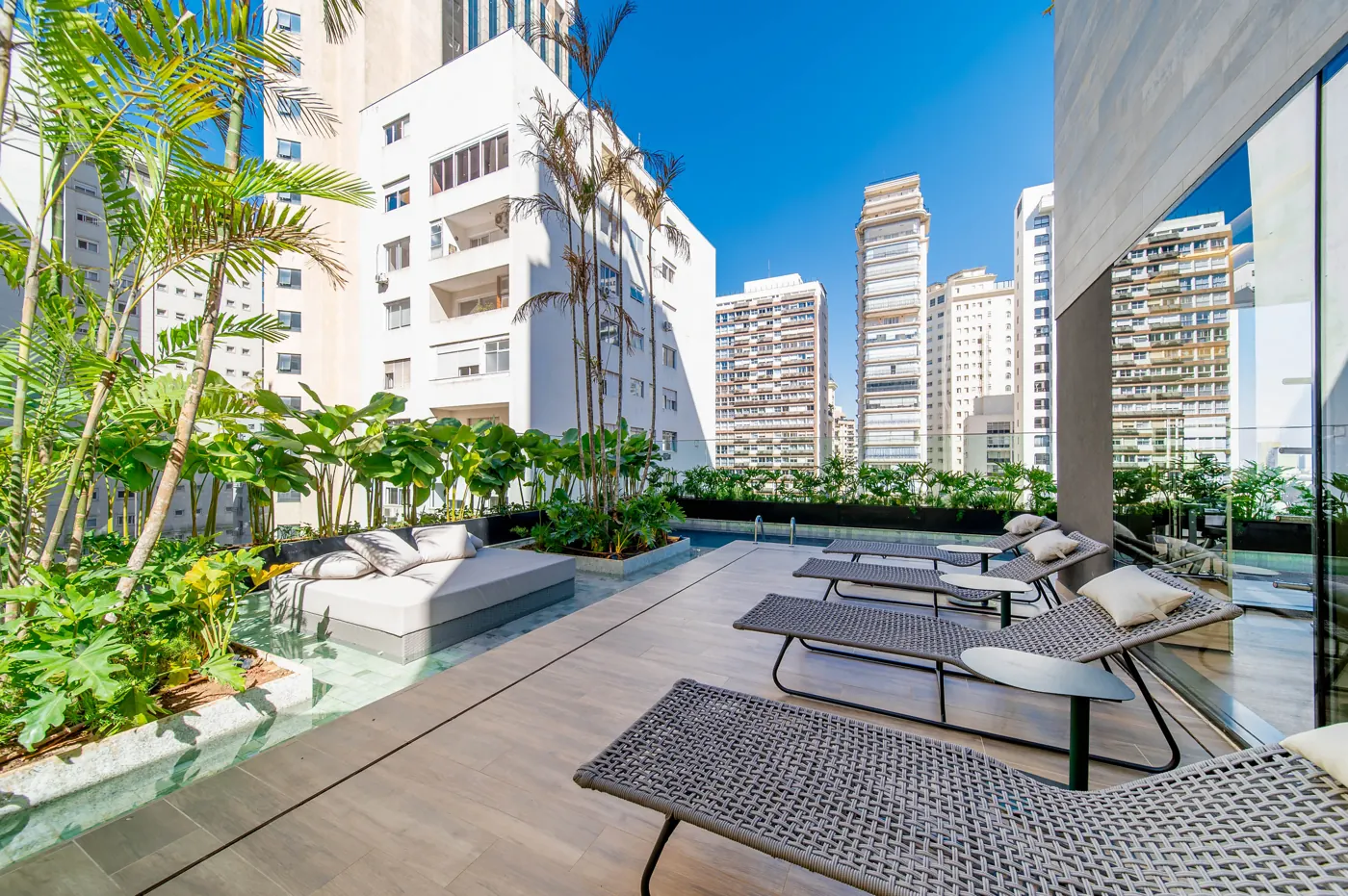 Deck molhado com espreguiçadeiras e vista para a cidade